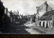 Zerstörte Dorfstraße mit schwer beschädigten Häusern und Trümmern im Ersten Weltkrieg