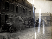 Deutsche Soldaten auf Lastkraftwagen und Pferdefuhrwerken vor Backsteingebäude im Ersten Weltkrieg