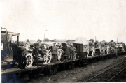 Militärtransport mit Geschützen und Fahrzeugen auf Eisenbahnwaggons