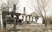 Deutsche Soldaten bei zerstörtem Wohnhaus mit Wasserpumpe im Ersten Weltkrieg