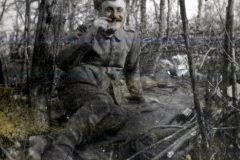 Ein soldat entspannt sich in der natur während des krieges, umgeben von bäumen und geäst