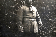 Ein Soldat in Uniform auf einem militärischen Gelände in der Natur zur Zeit des Ersten Weltkriegs