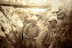 Deutsche Soldaten in einem Schützengraben während des Ersten Weltkriegs, umgeben von sandgefüllten Säcken
