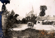 Historisches Dorfleben mit Kirche im Hintergrund und einem Landarbeiter bei der Arbeit