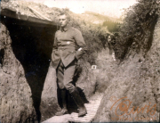 Ein Soldat schreitet durch einen Schützengraben während des Ersten Weltkriegs in einer ruhigen Momentaufnahme