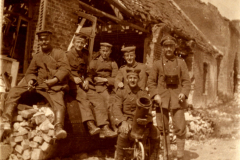 Sechs Soldaten posieren stolz vor einer zerstörten Kulisse während des Ersten Weltkriegs in Mitteleuropa