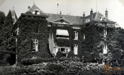 Historisches Herrenhaus umgeben von grünen Ranken in voller Blüte während einer warmen Sommertagsfeier