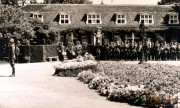 Historische Versammlung im Pfarrgarten mit uniformierten Soldaten und einer Gruppe von Zuschauern