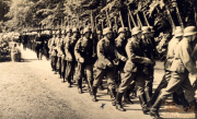 Soldaten marschieren in strenger Formation durch den Wald während des frühen Morgens im 20. Jahrhundert