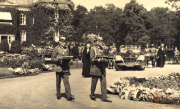 Historische Zeremonie mit uniformierten Offizieren und festlichem Empfang in einer malerischen Gartenanlage im 20. Jahrhundert