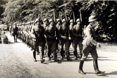 Soldaten marschieren entlang eines Waldes während des Zweiten Weltkriegs in einer historischen Aufzeichnung