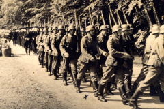 Soldaten marschieren in strenger Formation durch den Wald während des frühen Morgens im 20. Jahrhundert