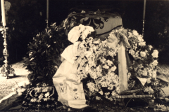 Ein Ort der Trauer und des Gedenkens, umgeben von Blumen und Kerzen in einer ehrwürdigen Umgebung
