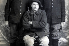 Drei Soldaten in historischer Uniform posieren stolz vor einer neutralen Kulisse