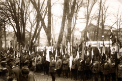 Historische Versammlung von Soldaten mit Fahnen im Stadtzentrum während der frühen Morgenstunden des 20. Jahrhunderts