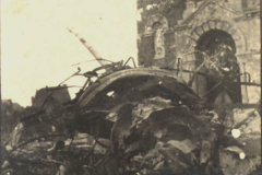 Zerstörte Ruinen eines ehemaligen Gebäudes in einer kriegsgeplagten Stadt, umgeben von den Überresten eines Flugzeugs