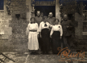 Impressionen aus dem Ersten Weltkrieg mit Zivilisten und Soldaten vor einem Haus in der Nähe der Front