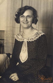 Ein Porträt einer lächelnden Frau in einem eleganten Kleid mit Spitzenkragen aus den 1920er Jahren