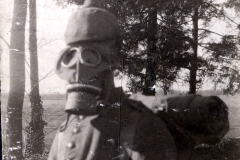 Soldat mit Gasmaske während des Ersten Weltkriegs in einer bewaldeten Landschaft