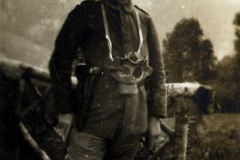 Soldat im Ersten Weltkrieg mit Gasmaske vor einer Waldlandschaft