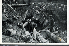 Soldaten inspizieren Schützengraben während des Ersten Weltkriegs in einem bewaldeten Gebiet