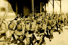 Soldaten im Ersten Weltkrieg marschieren in einer Stadt während des Kriegsjahres mit Tagebuchkommentaren