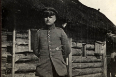 Ein deutscher Soldat im Ersten Weltkrieg vor einer thematisierten Unterkunft in einem Feldlager