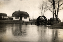 Wassermühle im ländlichen Raum während des Ersten Weltkriegs mit bewölkem Himmel und ruhigem Wasser