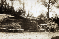 Soldaten im Ersten Weltkrieg vor einem befestigten Unterstand in einem Waldgebiet