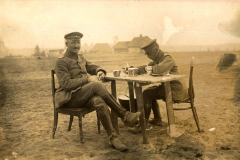 Soldaten sitzen an einem Tisch und genießen eine Pause während des Ersten Weltkriegs in einer ländlichen Umgebung