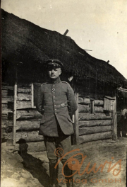 Ein deutscher Soldat im Ersten Weltkrieg vor einer thematisierten Unterkunft in einem Feldlager