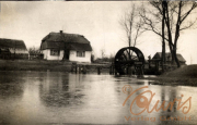 Wassermühle im ländlichen Raum während des Ersten Weltkriegs mit bewölkem Himmel und ruhigem Wasser