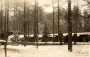 Soldaten stehen im Schnee vor einem Schützengraben des Ersten Weltkriegs in einem Waldgebiet