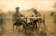Soldaten sitzen an einem Tisch und genießen eine Pause während des Ersten Weltkriegs in einer ländlichen Umgebung