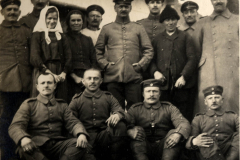 Gruppenfoto von Soldaten und Zivilisten während des Ersten Weltkriegs in einem ländlichen Umfeld