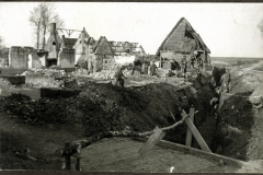 Zerstörte Landschaft nach Kämpfen im Ersten Weltkrieg mit Soldaten in Schützengräben und Trümmern