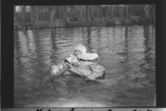 Ein Mann in einem improvisierten Boot während des Ersten Weltkriegs in einer ruhigen Wasserlandschaft