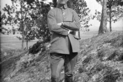 Soldat im Ersten Weltkrieg posiert am Waldrand mit Blick auf das Schlachtfeld