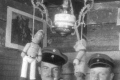 Soldaten des Ersten Weltkriegs bei einem geselligen Abend im Schützengraben mit traditionellen Puppen und einer Petroleumlampe