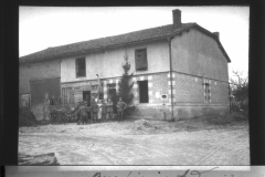 Soldaten posieren vor einem Unterkunftsgebäude im besetzten Gebiet während des Ersten Weltkriegs. Die Szene ist im Kontext von Rouvroy und den Ardennen zu verstehen und zeigt Aspekte des Soldatenlebens.