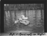 Ein Mann in einem improvisierten Boot während des Ersten Weltkriegs in einer ruhigen Wasserlandschaft