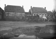 Soldaten transportieren Waren mit einer Pferdekutsche in einem belagerten Dorf während des Ersten Weltkriegs
