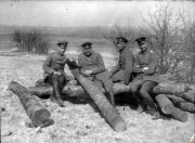 Soldaten sitzen auf Baumstämmen während des Ersten Weltkriegs in einer ländlichen Umgebung