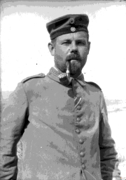 Soldat im Ersten Weltkrieg mit Pfeife vor einer offenen Landschaft