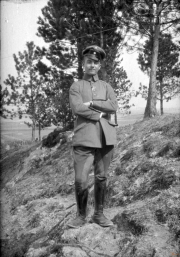 Soldat im Ersten Weltkrieg posiert am Waldrand mit Blick auf das Schlachtfeld