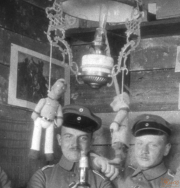 Soldaten des Ersten Weltkriegs bei einem geselligen Abend im Schützengraben mit traditionellen Puppen und einer Petroleumlampe