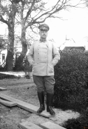 Soldat im Ersten Weltkrieg posiert in Uniform vor einem Garten in Europa