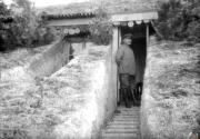 Soldat steht vor einem Eingangsbereich einer Bunkeranlage im Ersten Weltkrieg in Europa