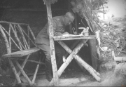 Soldat sitzt an einem Tisch und schreibt während des Ersten Weltkriegs in einem Graben