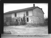 Soldaten posieren vor einem Unterkunftsgebäude im besetzten Gebiet während des Ersten Weltkriegs. Die Szene ist im Kontext von Rouvroy und den Ardennen zu verstehen und zeigt Aspekte des Soldatenlebens.